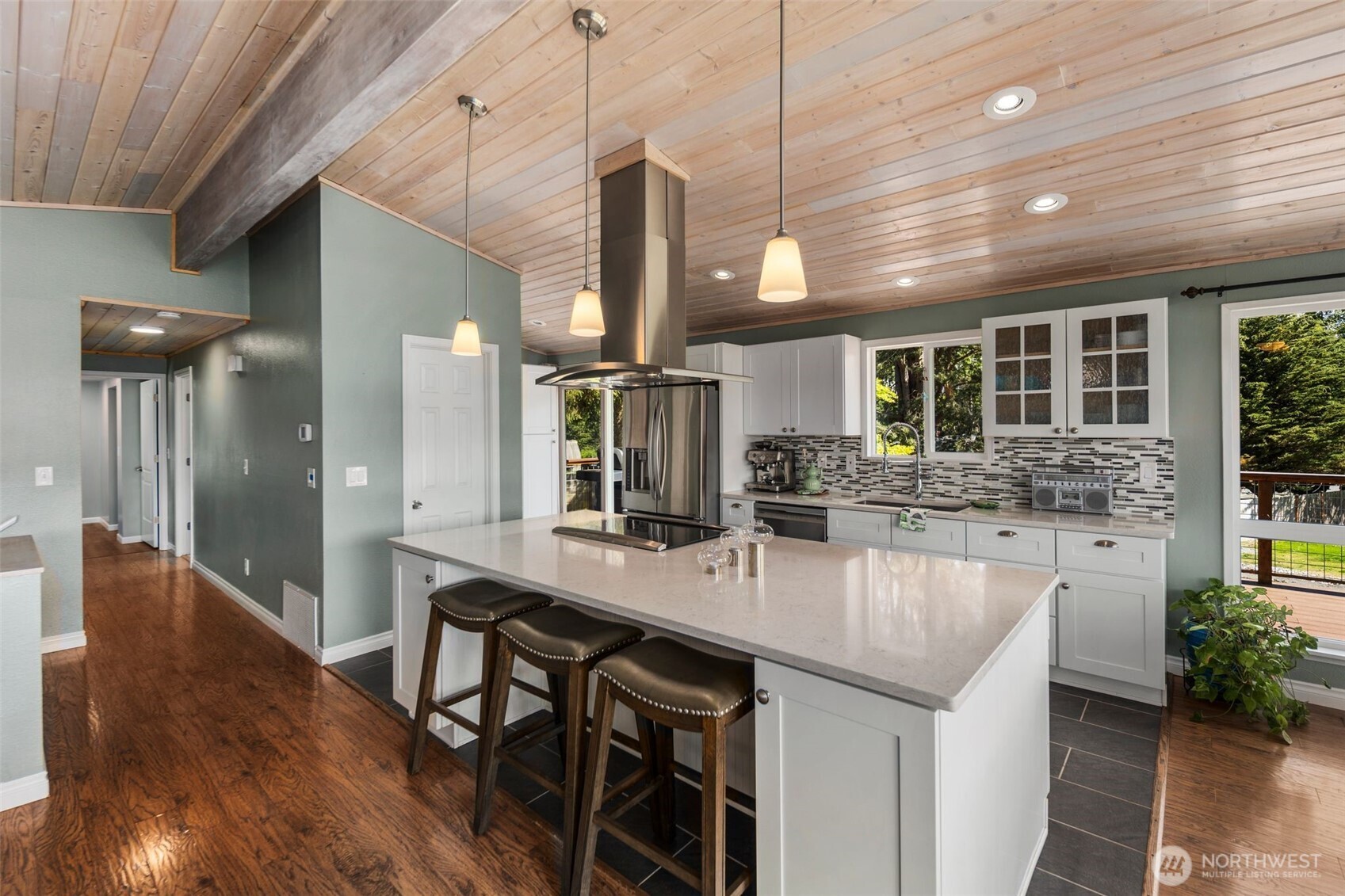 734 Shore Road Port Angeles, WA 98362 - Photo 13 of 40 a dining hall with stainless steel appliances granite countertop a kitchen island a stove a sink a dining table and chairs with wooden floor