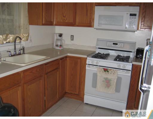 15 Mercury Road Edison, NJ 08817 - Photo 7 of 10 a kitchen with a stove sink and cabinets