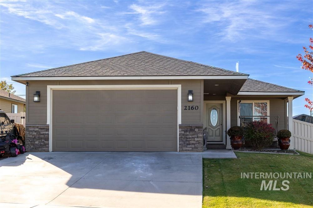 2160 East Ridgeview Avenue Payette, ID 83661 - Photo 1 of 32 Exterior featuring stone and siding finishes, an attached two-car garage, a concrete driveway, and a front entry with a decorative glass door