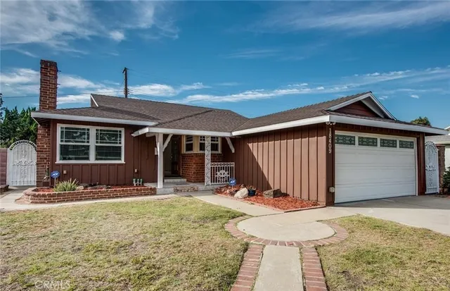 a front view of a house with a garden and yard
