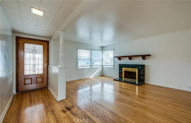 an empty room with wooden floor and fireplace