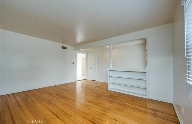 a view of an empty room with wooden floor