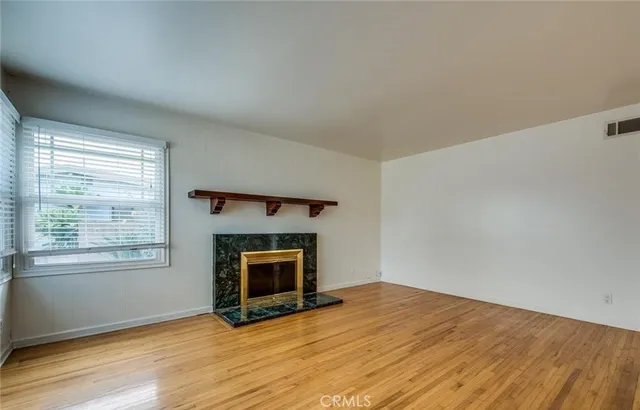 an empty room with a fireplace and windows