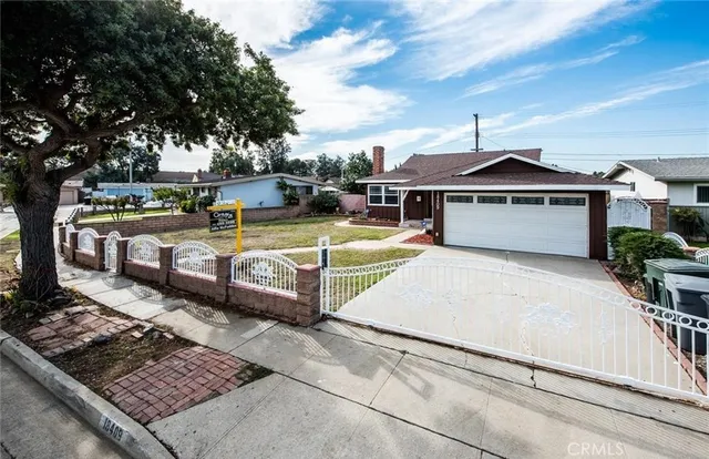 a view of a white house with a large pool and couches chairs under an umbrella