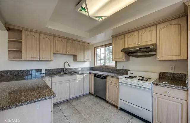 a kitchen with stainless steel appliances granite countertop a sink stove and cabinets