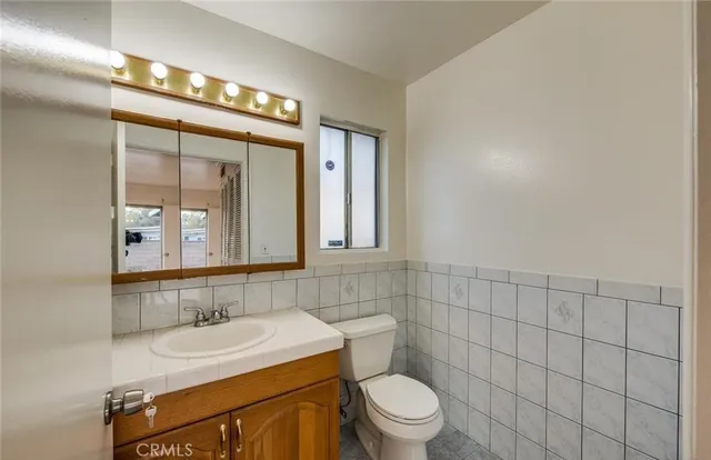 a bathroom with a sink a toilet and mirror