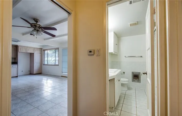 a view of a hallway with a livingroom and a bathroom