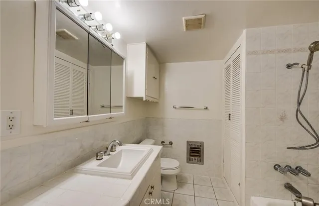 a bathroom with a sink mirror and toilet