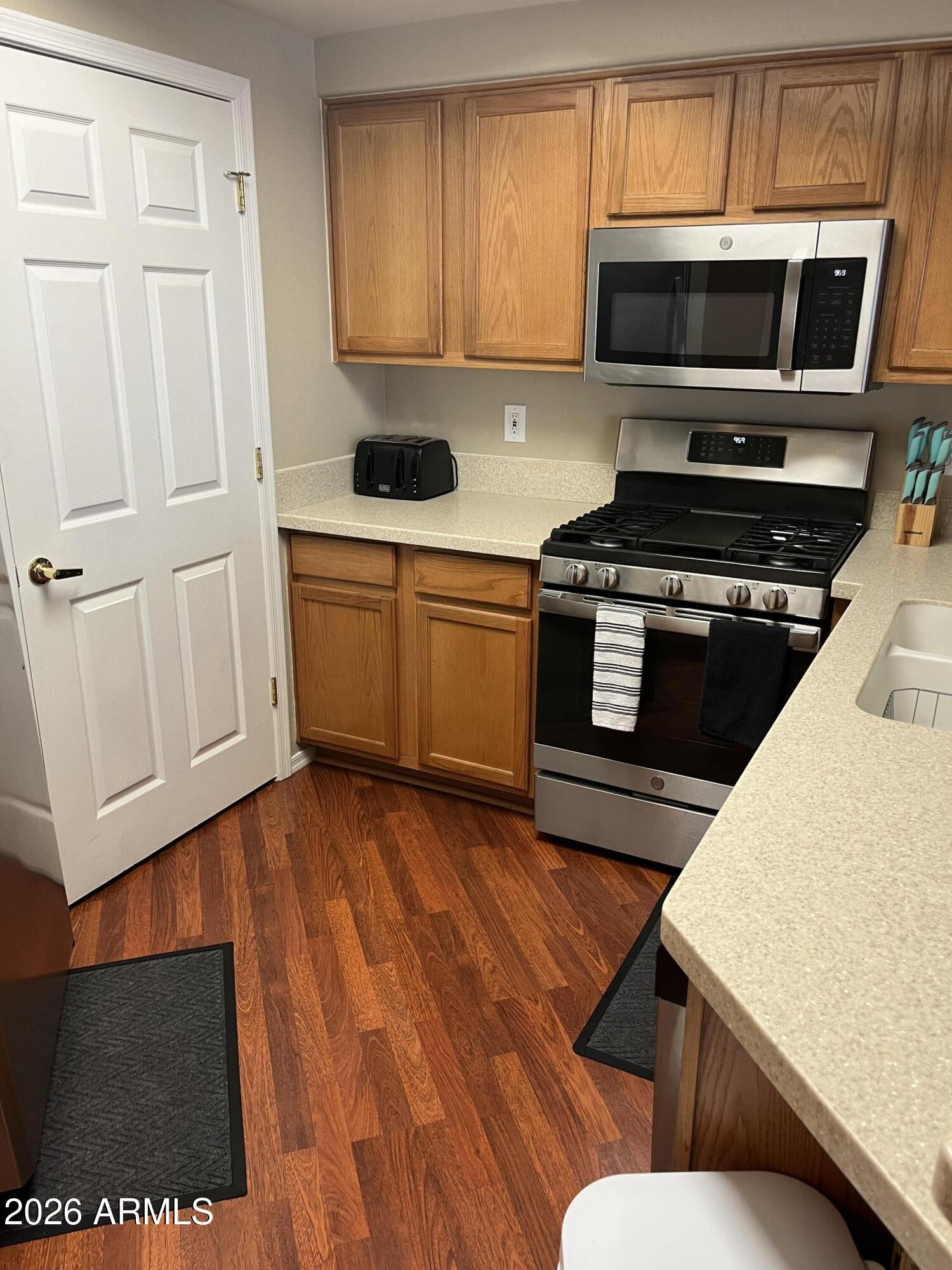 10030 West Indian School Road, Unit 133 Phoenix, AZ 85037 - Photo 11 of 17 a kitchen with a refrigerator stove top oven and sink