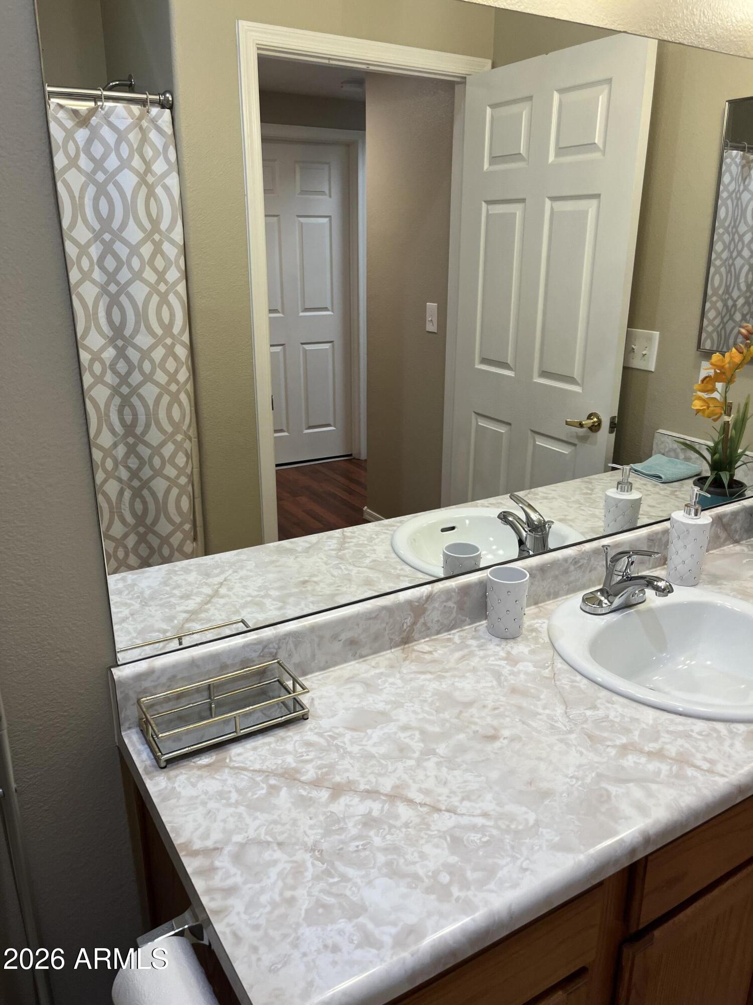10030 West Indian School Road, Unit 133 Phoenix, AZ 85037 - Photo 14 of 17 a bathroom with a granite countertop sink and a mirror