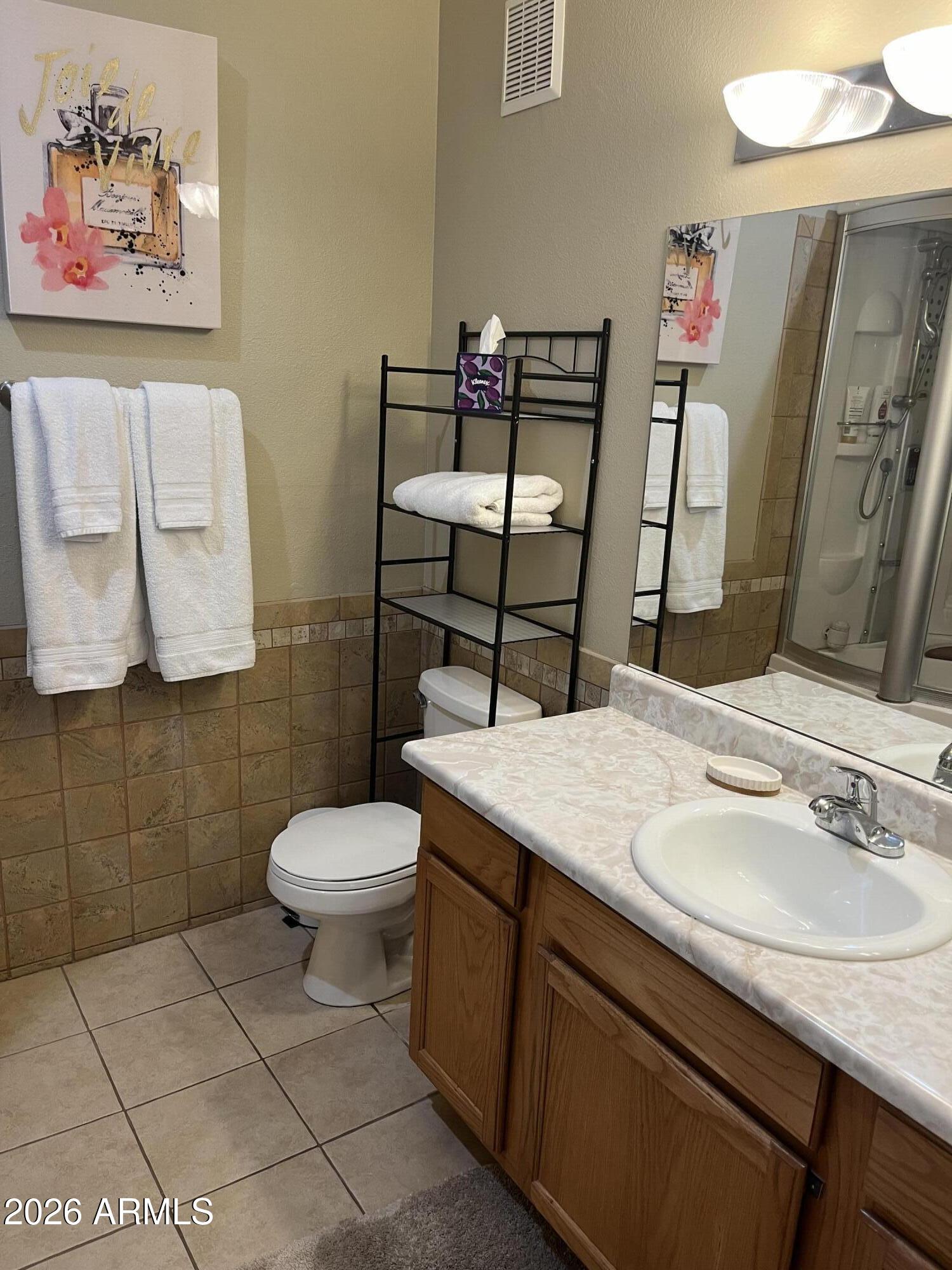 10030 West Indian School Road, Unit 133 Phoenix, AZ 85037 - Photo 5 of 17 a bathroom with a sink mirror vanity and toilet