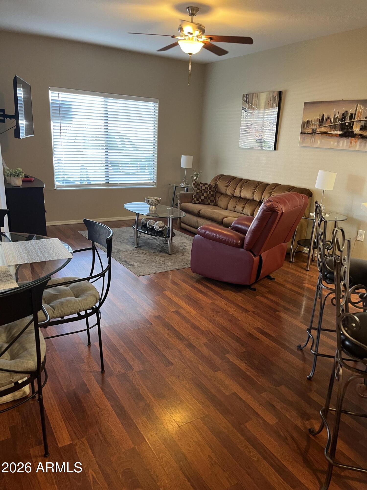 10030 West Indian School Road, Unit 133 Phoenix, AZ 85037 - Photo 6 of 17 a living room with furniture and a wooden floor