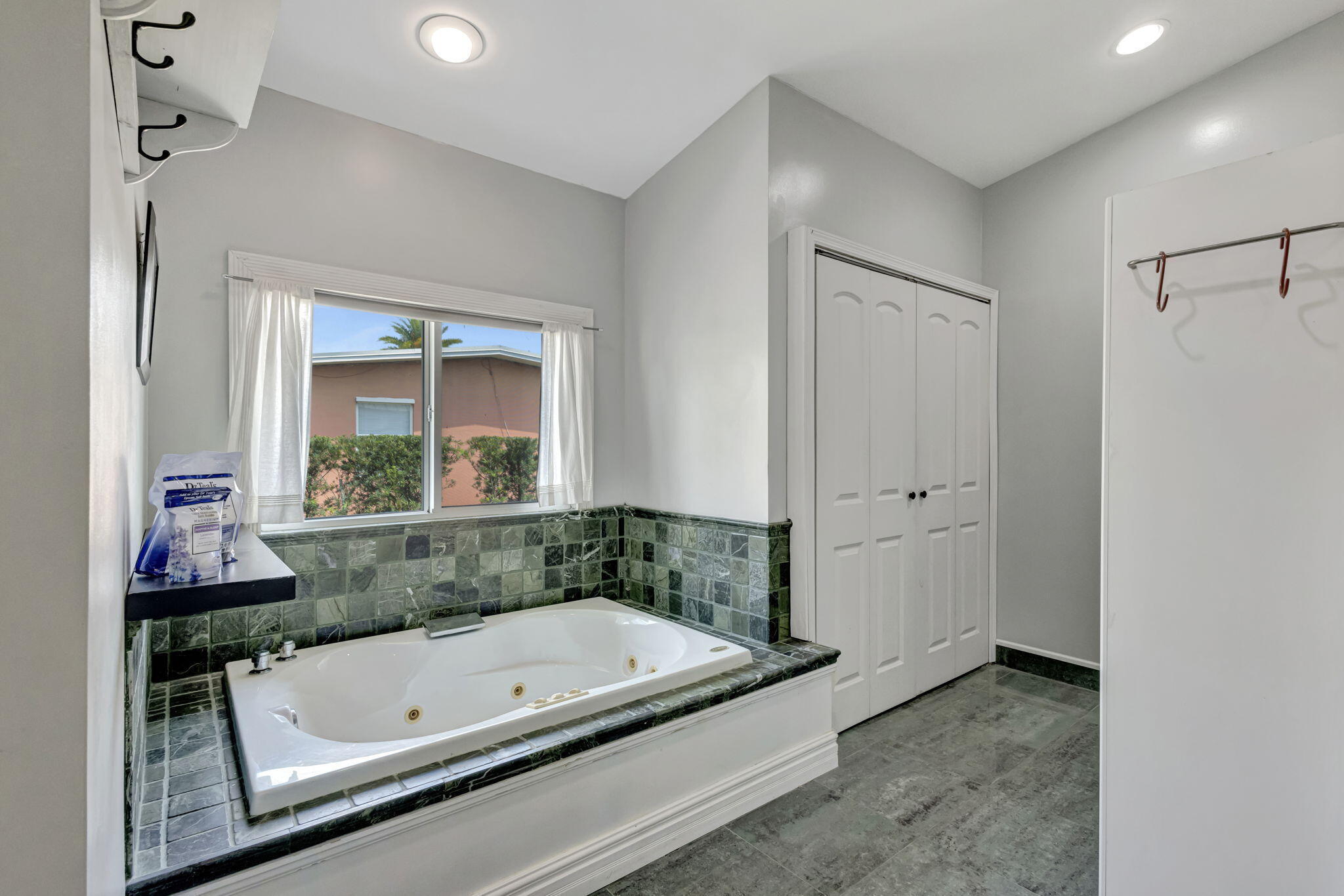 2940 Southeast Treasure Island Road Port St. Lucie, FL 34952 - Photo 36 of 61 a bathroom with a tub and a large mirror