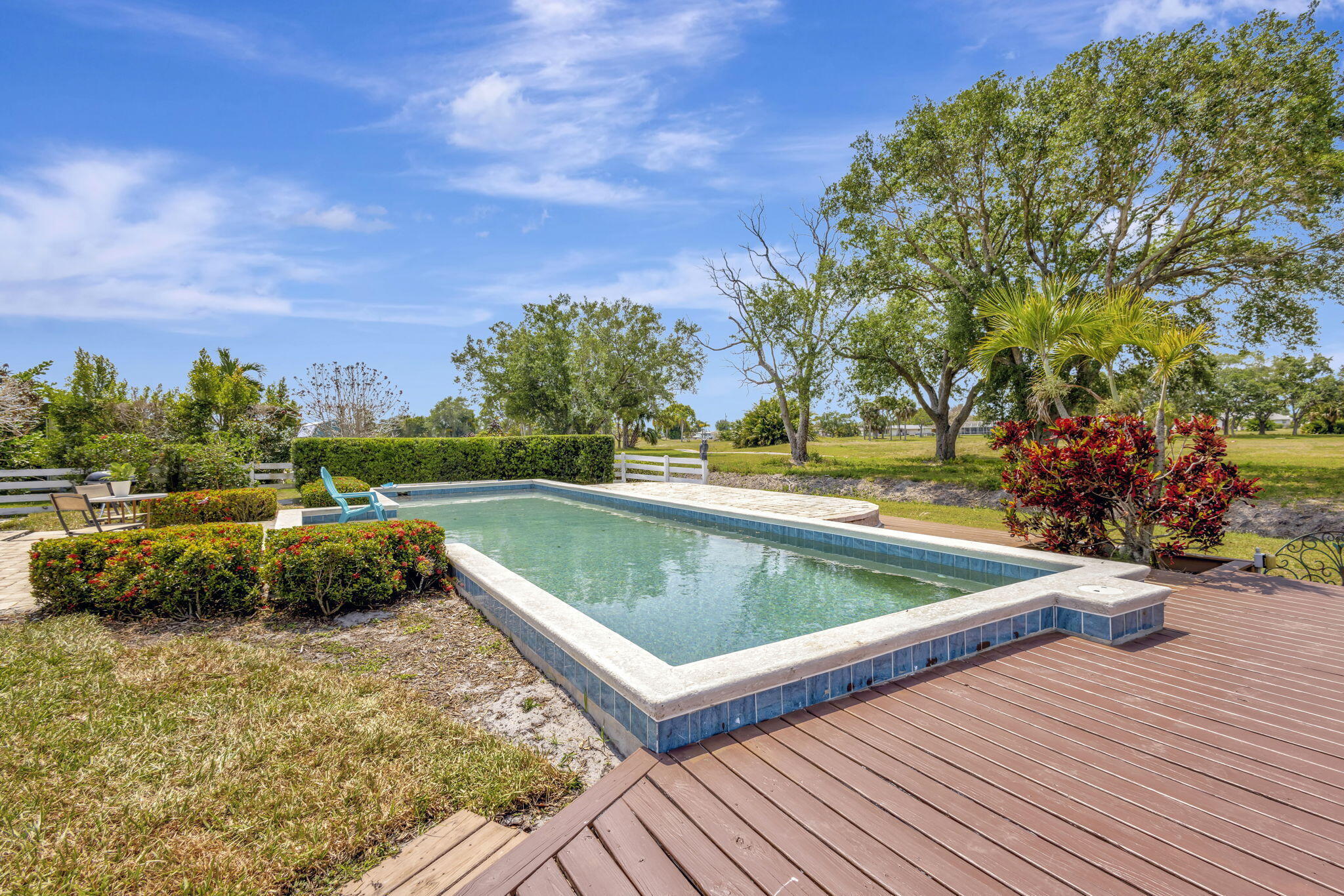 2940 Southeast Treasure Island Road Port St. Lucie, FL 34952 - Photo 42 of 61 a view of a swimming pool with a yard and plants