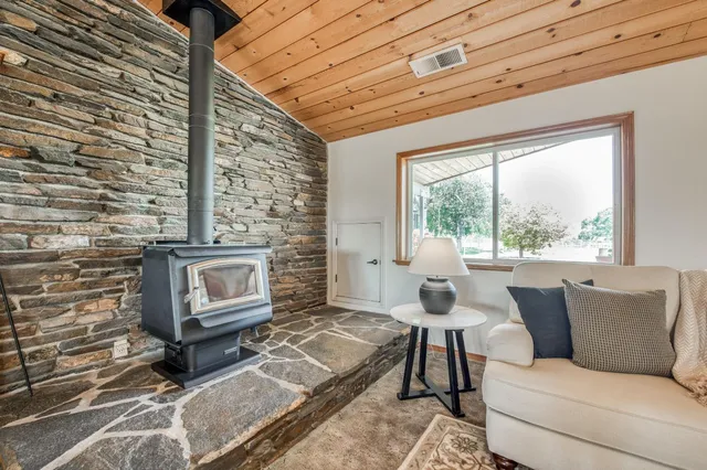 a large white kitchen with wooden floor and a large window
