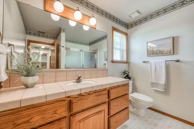 a bathroom with a granite countertop sink and a large mirror