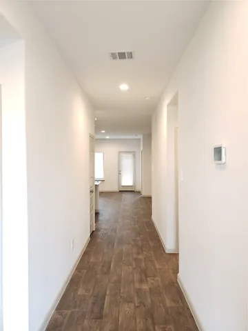a view of a hallway with wooden floor