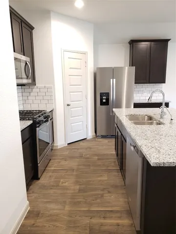 a kitchen with stainless steel appliances granite countertop a refrigerator stove and oven