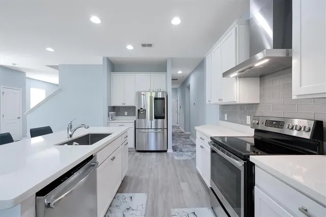 a kitchen with granite countertop a sink a counter space stainless steel appliances and cabinets