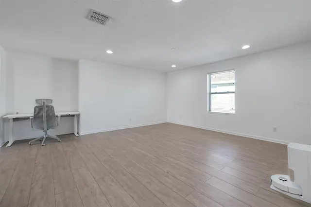 a spacious bedroom with a bed and a chandelier