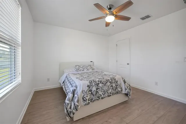 a bedroom with a bed and a ceiling fan