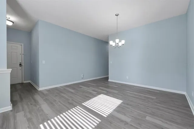 a view of a room with wooden floor and a chandelier