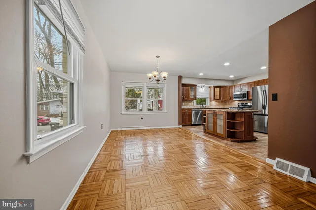 a view of large kitchen with stainless steel appliances granite countertop a stove and a refrigerator