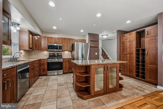 a kitchen with stainless steel appliances granite countertop a refrigerator and a stove top oven