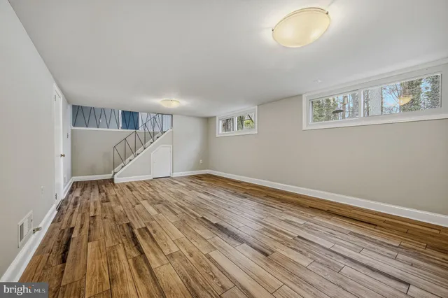 a view of empty room with wooden floor