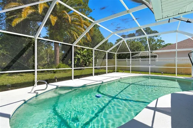 a large white kitchen with a sink and stainless steel appliances