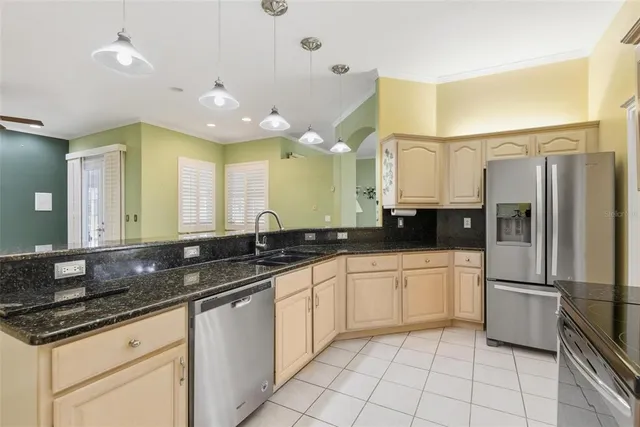 a kitchen with stainless steel appliances granite countertop a sink and a refrigerator