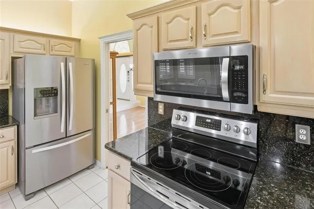 a kitchen with stainless steel appliances granite countertop a stove a sink and a microwave