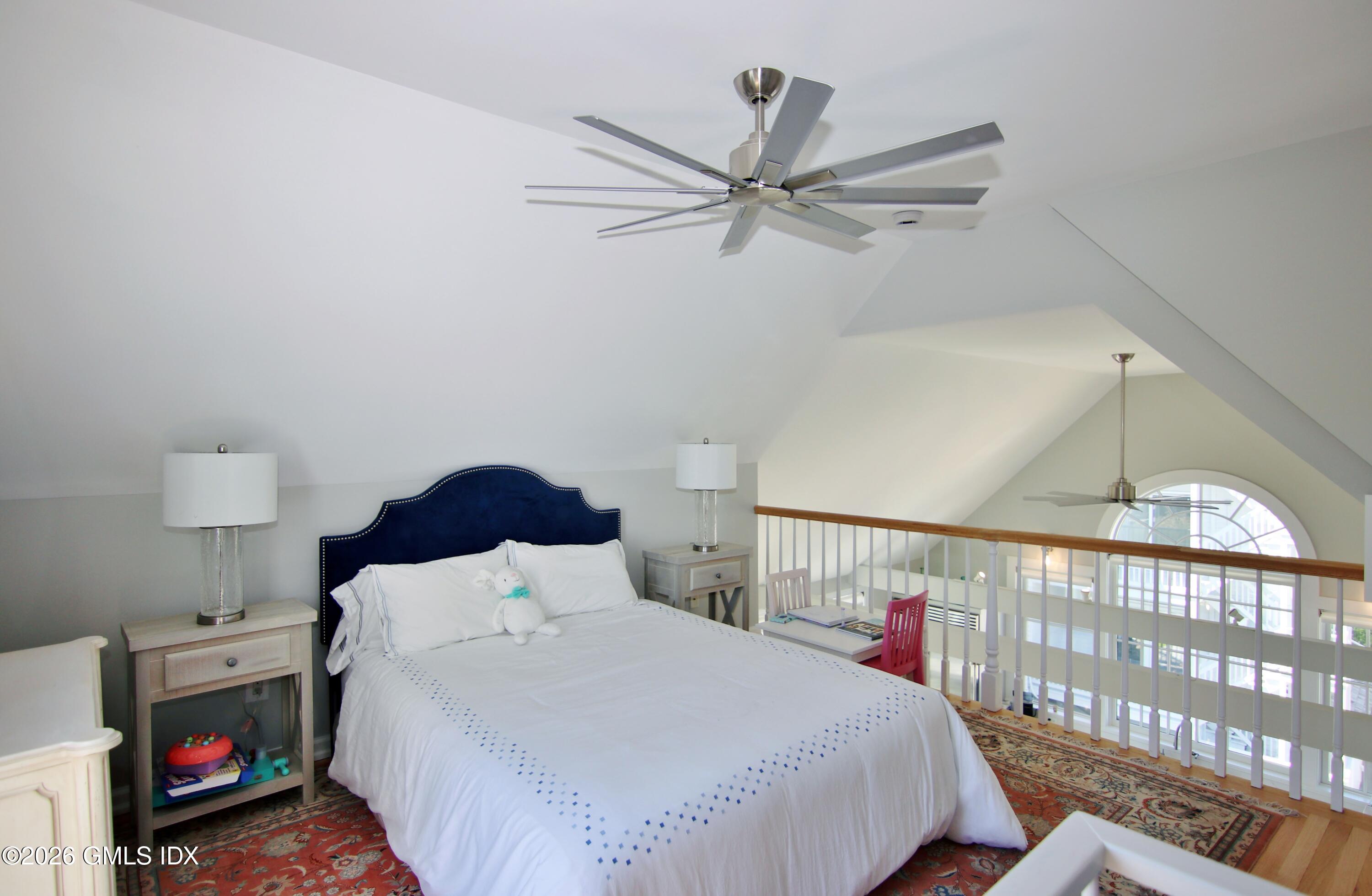 633 Steamboat Road, Unit 5 Greenwich, CT 06830 - Photo 22 of 29 a bedroom with a bed a window and a chandelier