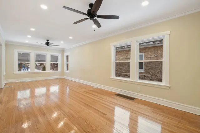 a view of an empty room with a window and wooden floor