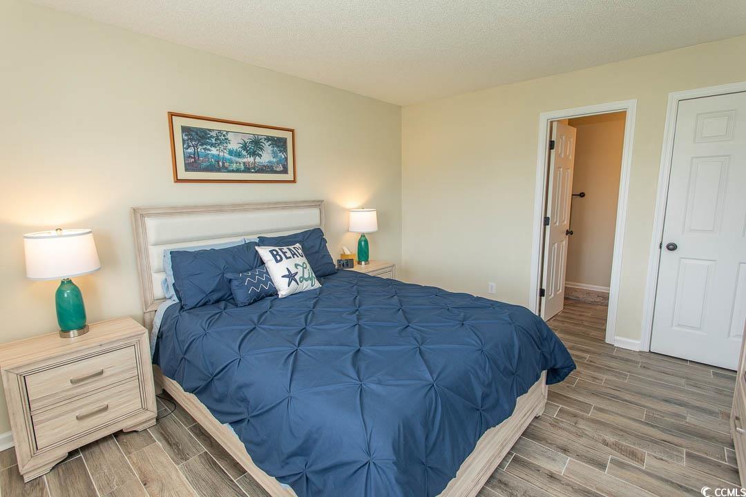 201 Landing Road, Unit D North Myrtle Beach, SC 29582 - Photo 16 of 40 Bedroom featuring baseboards, wood tiled floor, and a textured ceiling