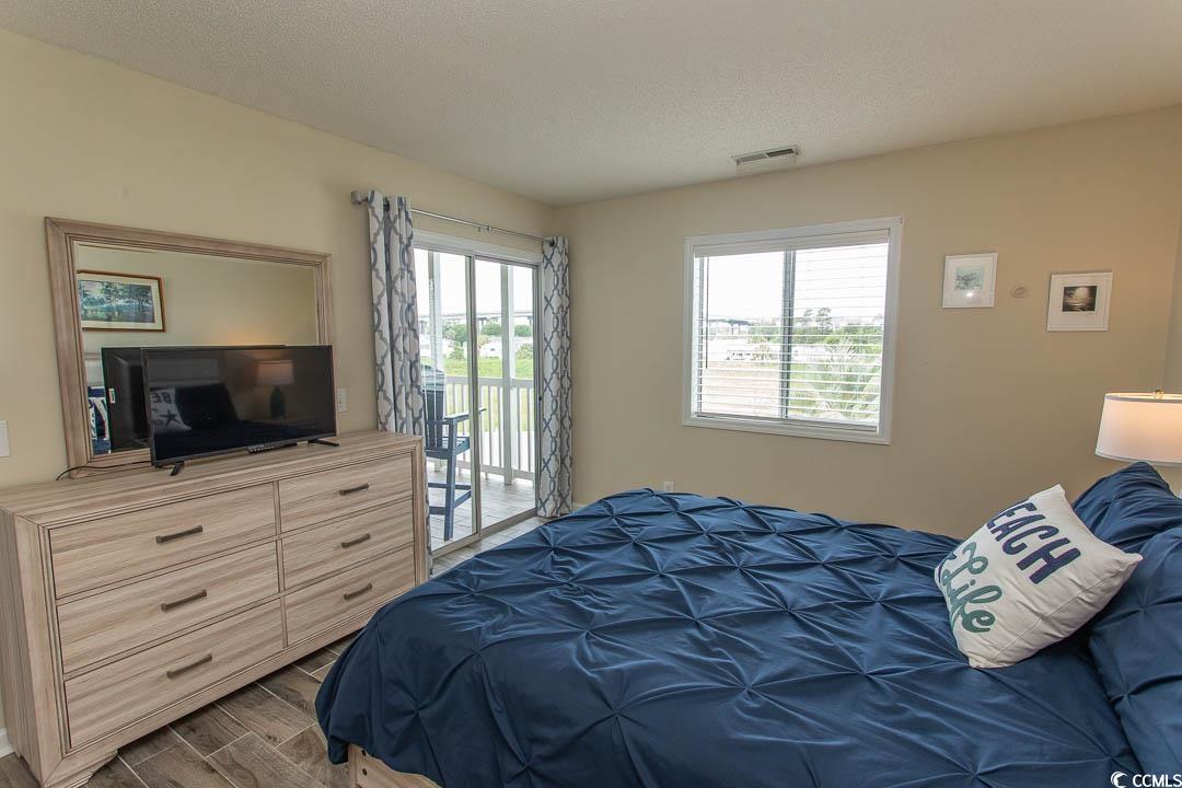 201 Landing Road, Unit D North Myrtle Beach, SC 29582 - Photo 19 of 40 Bedroom with access to outside, wood finished floors, and visible vents