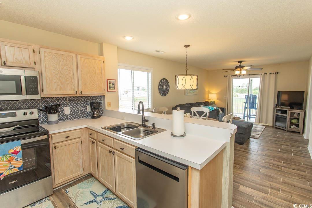 201 Landing Road, Unit D North Myrtle Beach, SC 29582 - Photo 39 of 40 Kitchen featuring stainless steel appliances, a peninsula, a sink, open floor plan, and light brown cabinets