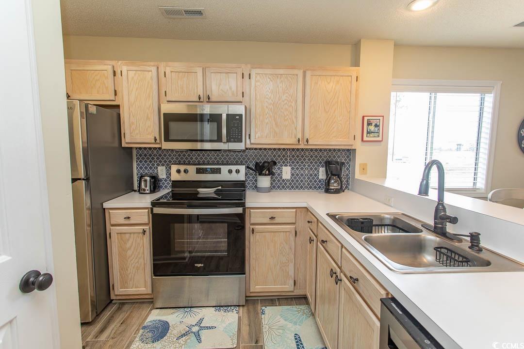 201 Landing Road, Unit D North Myrtle Beach, SC 29582 - Photo 4 of 40 Kitchen with visible vents, light brown cabinetry, stainless steel appliances, and a sink