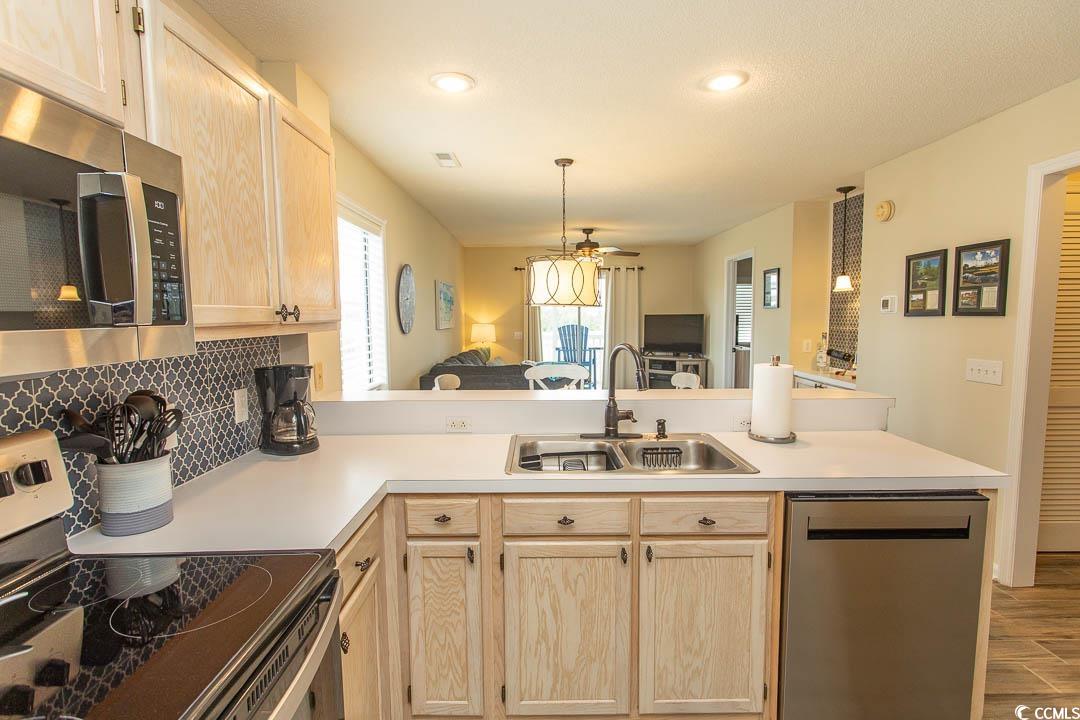 201 Landing Road, Unit D North Myrtle Beach, SC 29582 - Photo 5 of 40 Kitchen featuring a peninsula, light brown cabinetry, a sink, and appliances with stainless steel finishes