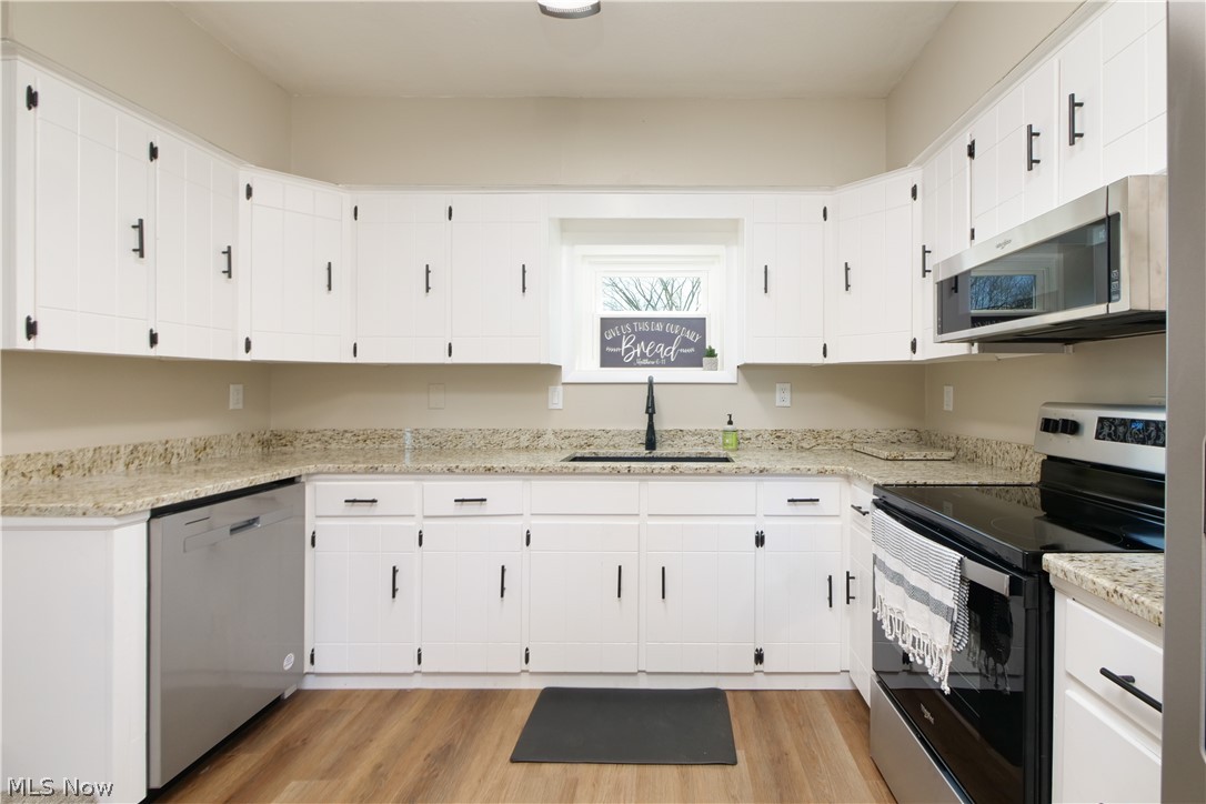 12379 Portage Street Rittman, OH 44270 - Photo 9 of 44 Kitchen featuring appliances with stainless steel finishes, light hardwood / wood-style flooring, sink, and white cabinets