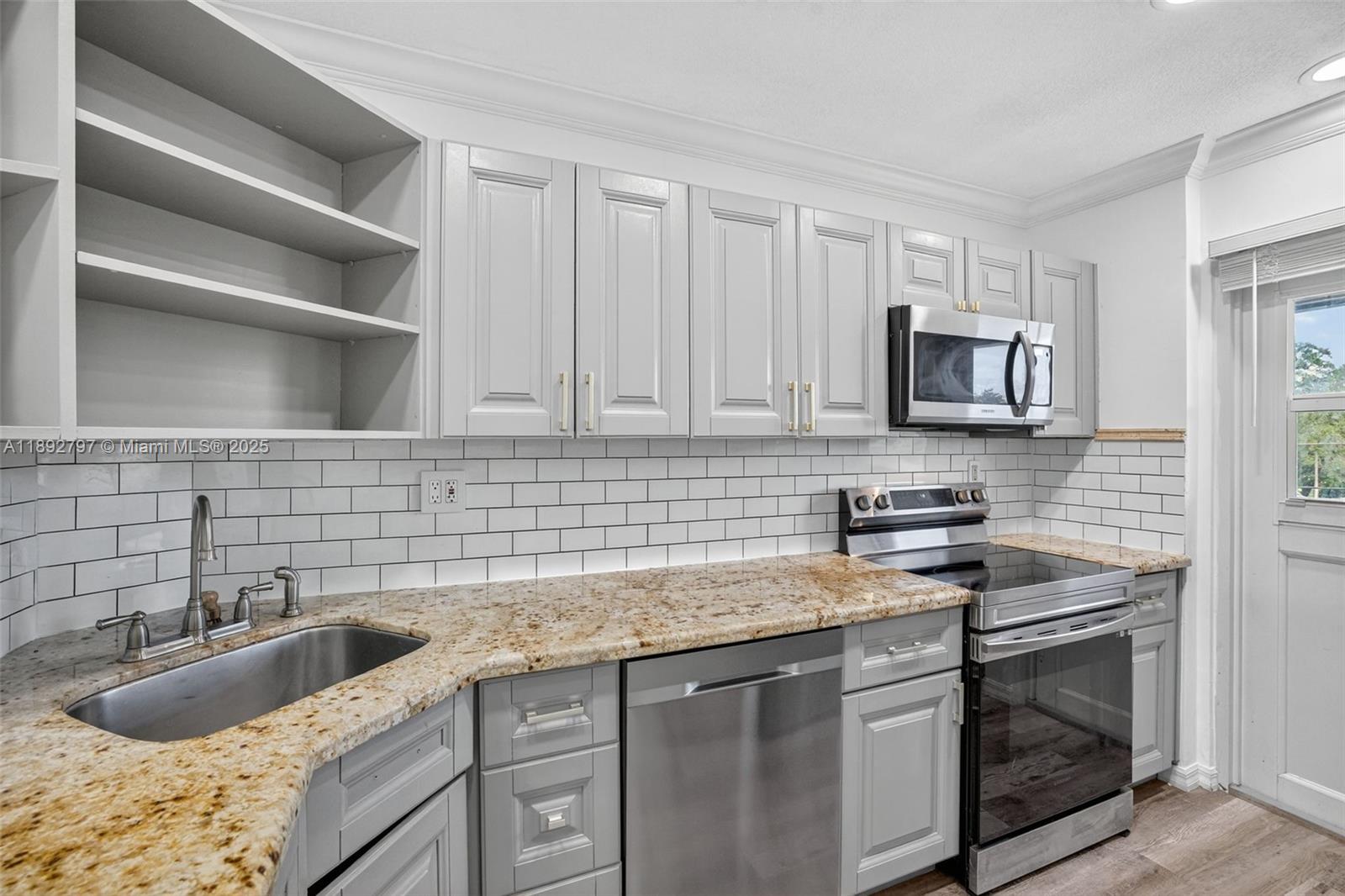 900 Southwest 12th Street, Unit 305 Fort Lauderdale, FL 33315 - Photo 29 of 72 Open Concept Kitchen w/ newer stainless appliances, granite counter, updated cabinets and subway backsplash. Second door to catwalk