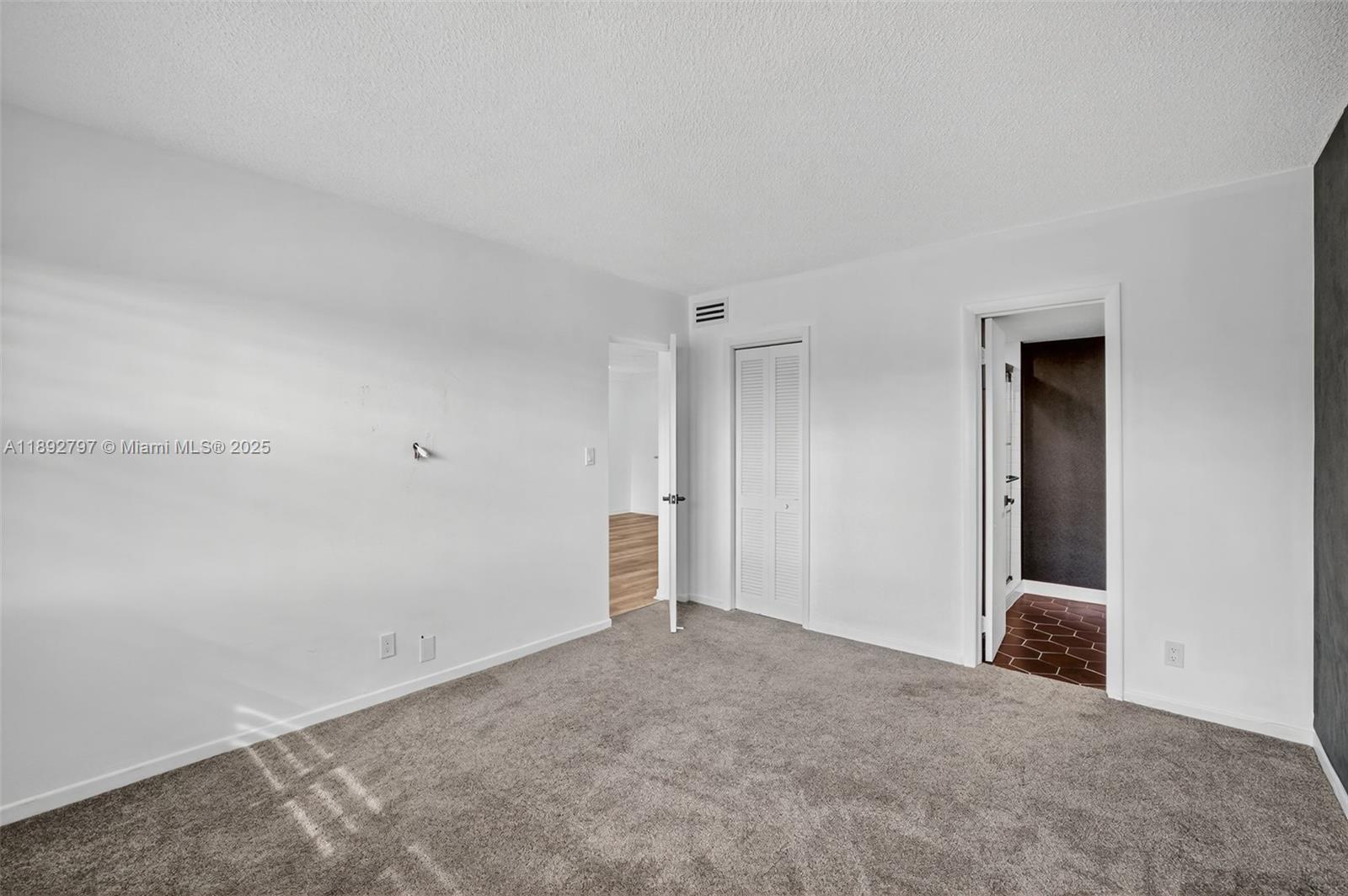 900 Southwest 12th Street, Unit 305 Fort Lauderdale, FL 33315 - Photo 36 of 72 Primary Bedroom w/ Impact Windows, louvered shutters, wallpapered feature wall and newer carpet in amazing condition. Flat ceilings