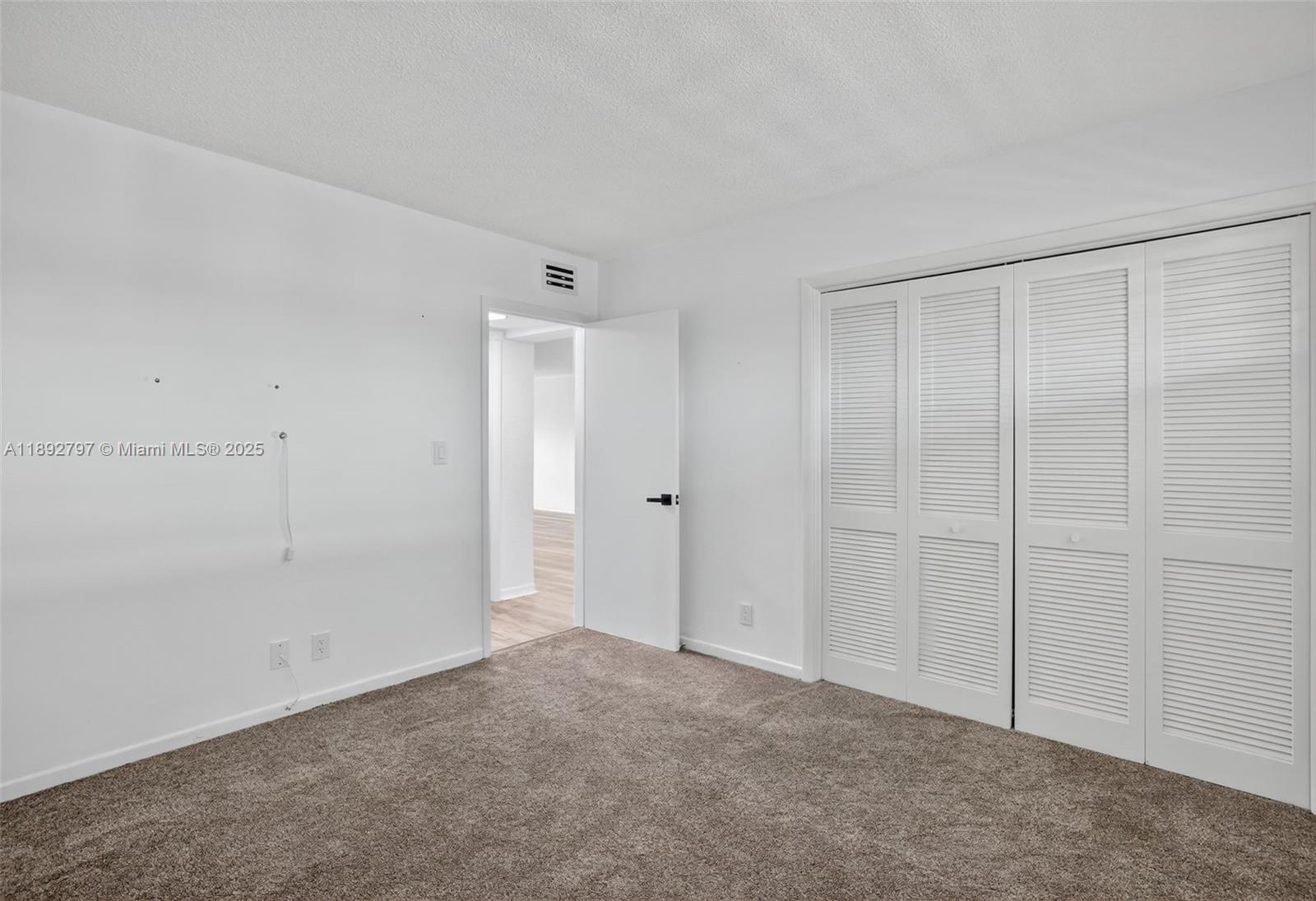 900 Southwest 12th Street, Unit 305 Fort Lauderdale, FL 33315 - Photo 40 of 72 Large guest bedroom w/ louvered shutters / impact windows, upgraded carpet and view to downtown from front windows