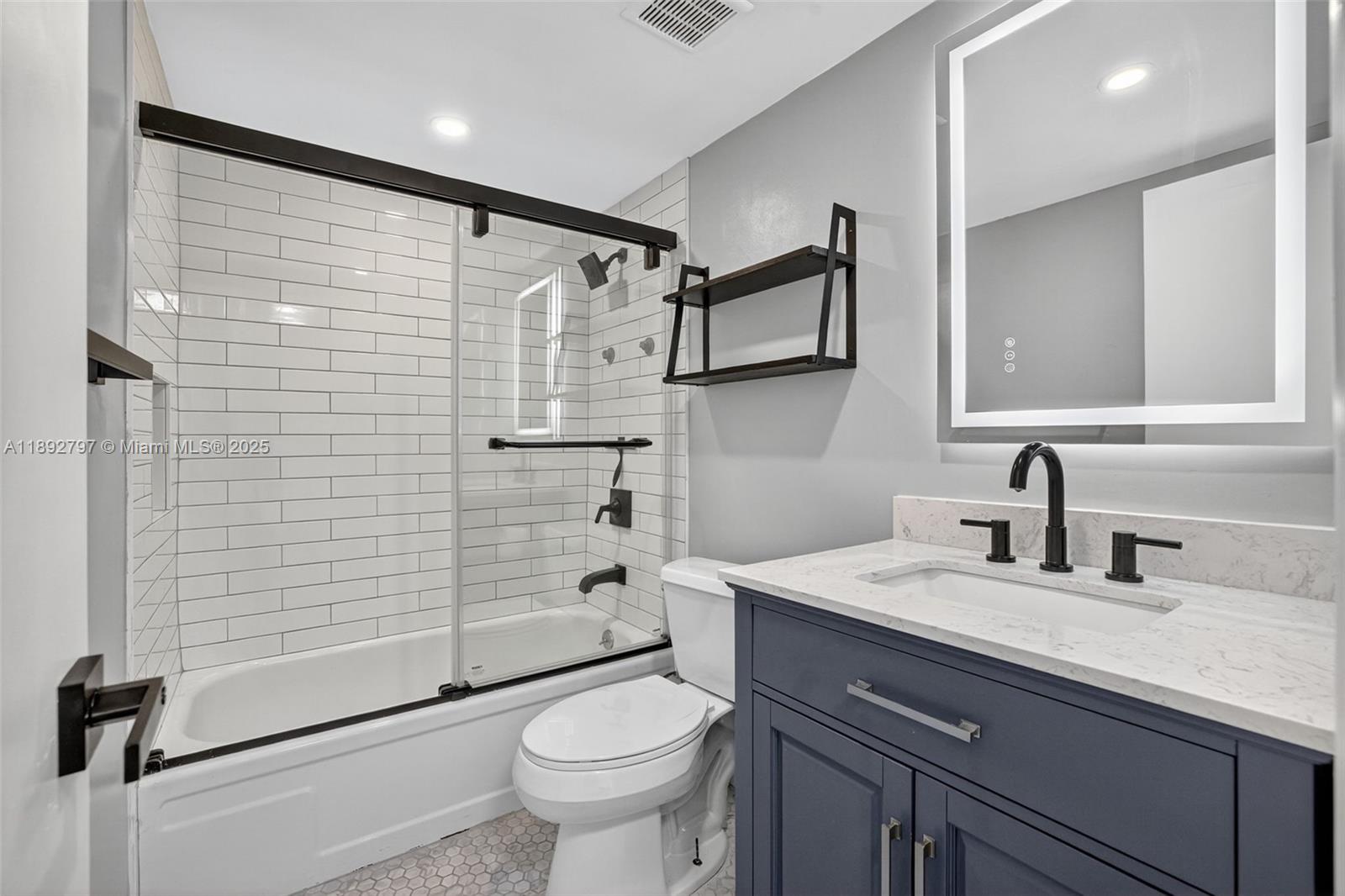 900 Southwest 12th Street, Unit 305 Fort Lauderdale, FL 33315 - Photo 42 of 72 Guest Bathroom w/ glass shower enclosure, combo tub / shower, updated vanity and backlit mirror