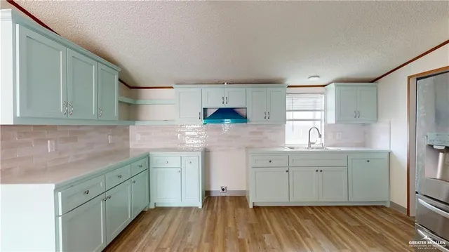 a kitchen with white cabinets sink and stove