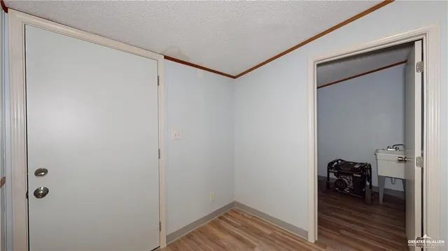 a view of a room with a window and wooden floor
