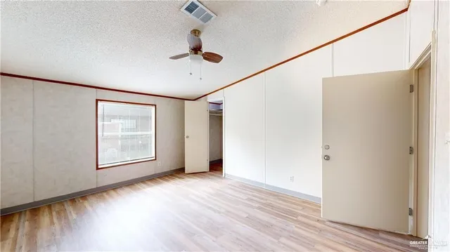 a view of a room with wooden floor closet and a ceiling fan