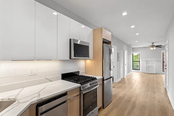 a kitchen with stainless steel appliances granite countertop a stove a sink and a refrigerator