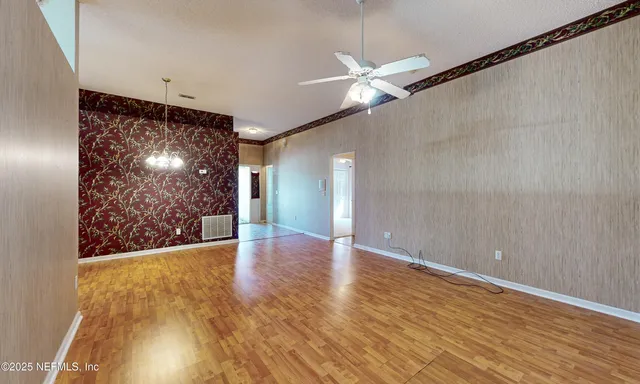 a view of an empty room with wooden floor