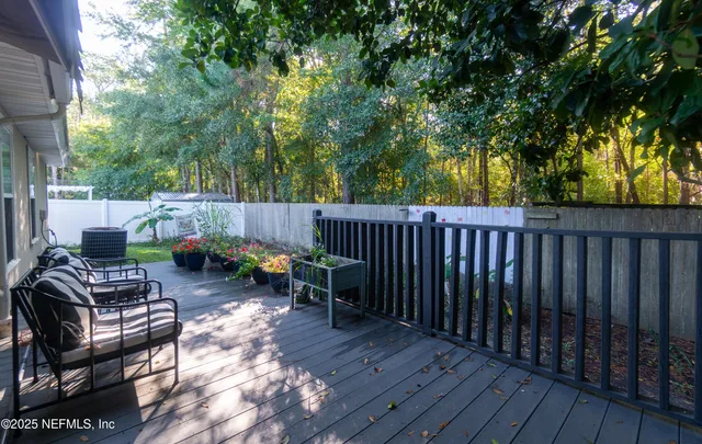 a view of backyard with deck and outdoor seating